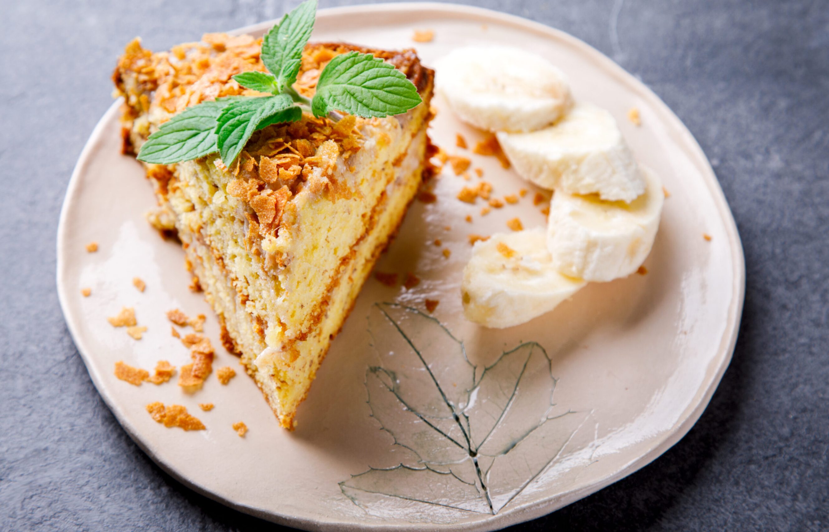 Pie with bananas, chocolate icing and fresh mint.Baking on the gray background.Copy space for Text.
